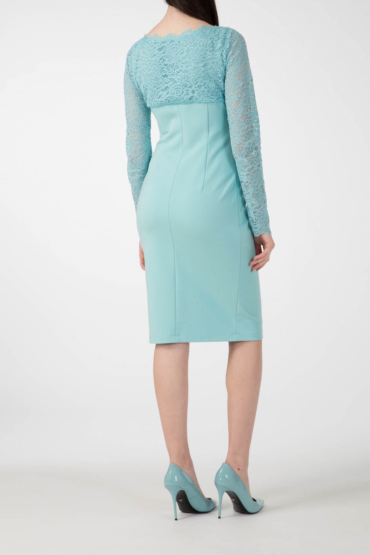 Dressed in the Antonio Croce Ampara Embroidered Lace Dress, which features an elegant light blue knee-length design with delicate lace long sleeves, a person stands in a neutral pose. They enhance their ensemble with matching blue high-heeled shoes against a plain white background.