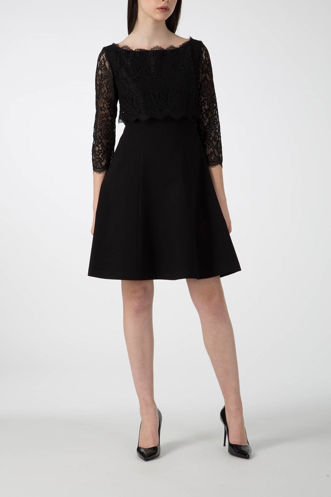 A person wearing the sophisticated Antonio Croce Artemide Two-Tone Dress, which features a lace bodice and an A-line silhouette, stands against a plain white background. They are also donning black high heels.