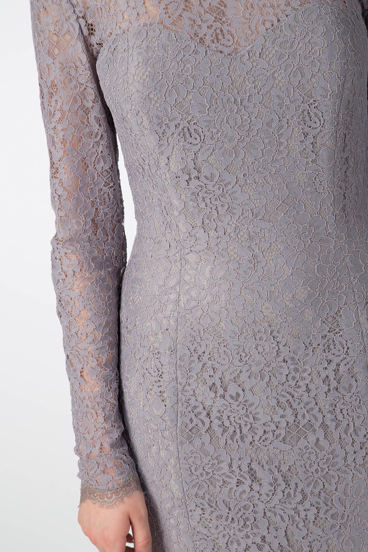 Dressed in the Antonio Croce Australia Allover Lace Gown, an individual elegantly displays its detailed lavender lace featuring an illusion neckline. The gown's exquisite floral design envelops the entirety of this vintage-inspired creation, emanating a sense of timeless sophistication, while its plunging back adds a modern touch.