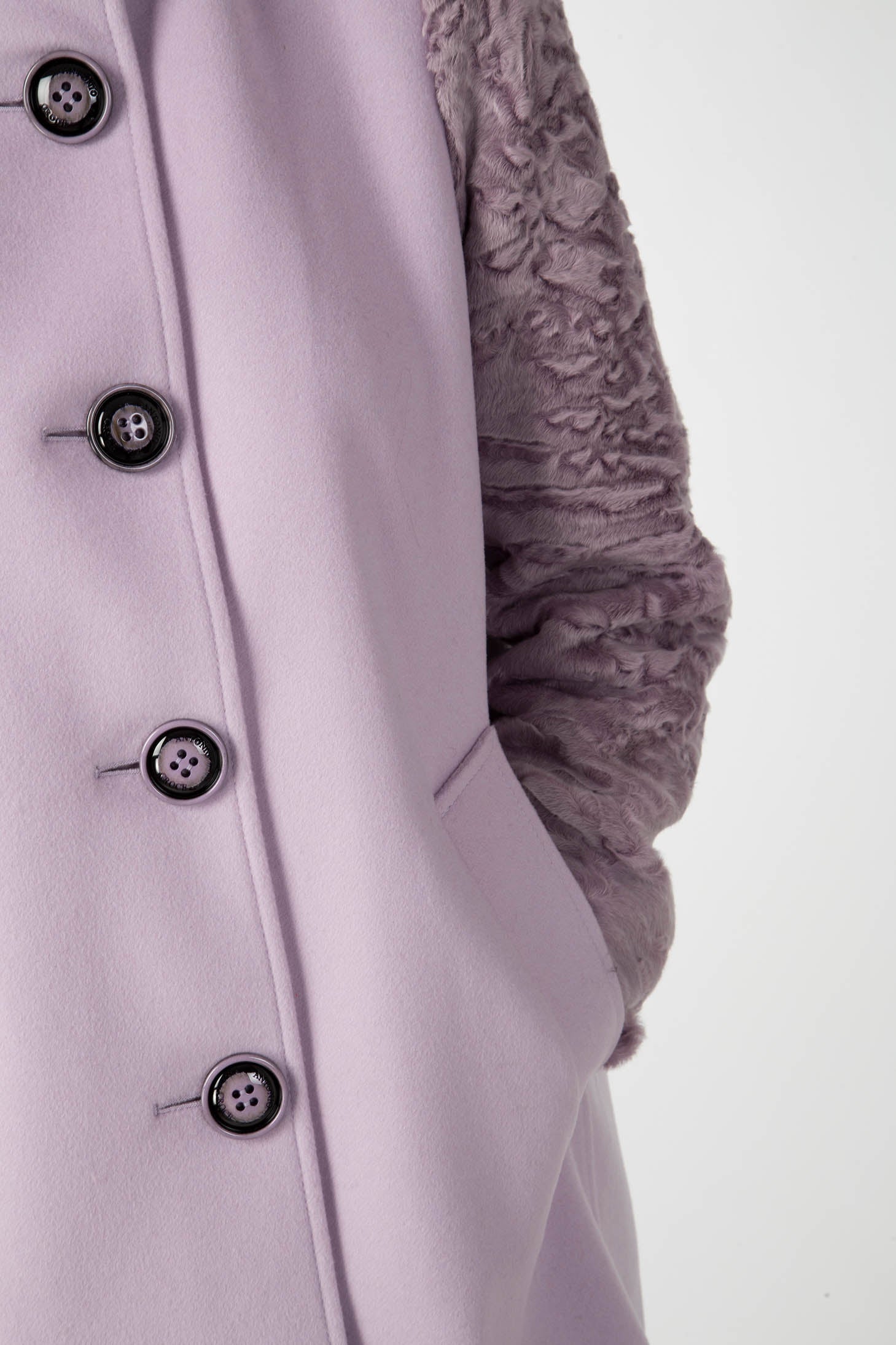 Close-up of the Antonio Croce Callie Textured Coat, highlighting the black buttons and distinctive fur-like sleeve details. This chic vintage garment also includes a side pocket, providing contrast to the sleek fabric.