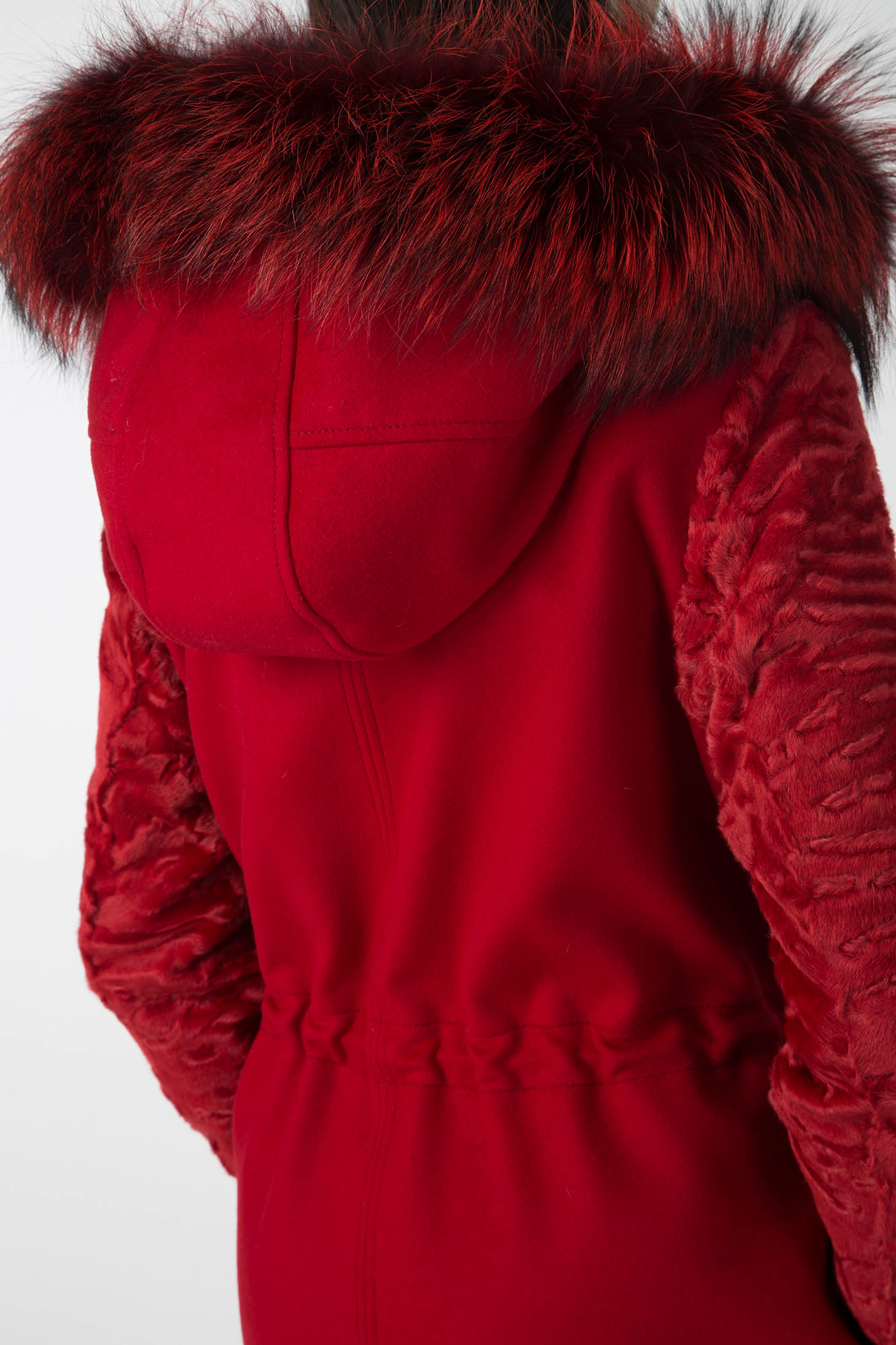 A person wearing the striking Antonio Croce Catrina Coat poses against a plain white background. This vintage piece, designed by Antonio Croce, features textured sleeves and a fitted waist, complemented by a fur-trimmed collar in dark red and black hues.