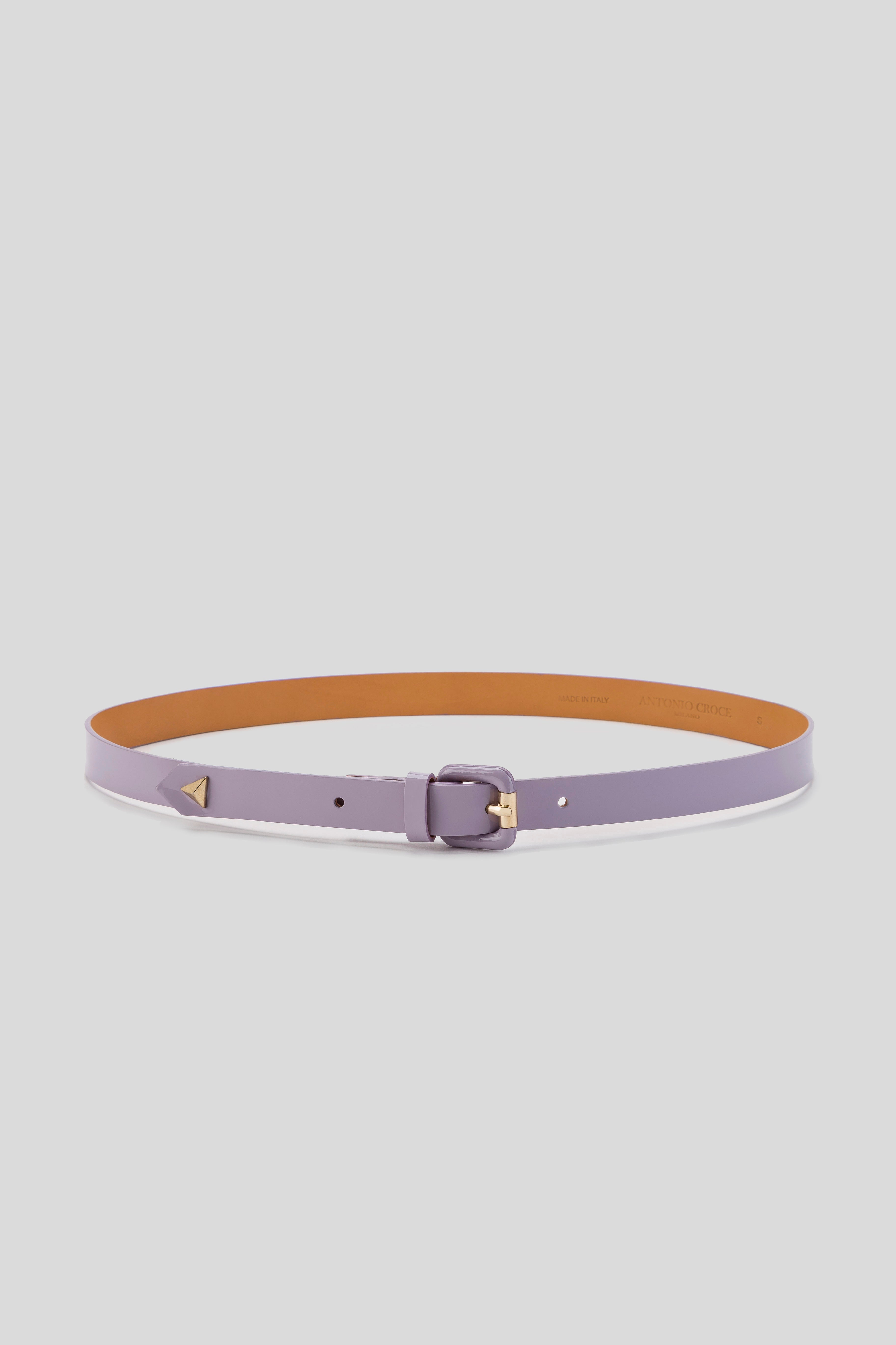 The Antonio Croce Linzi Leather Belt by Antonio Croce, showcasing its inner tan side, is a purple leather accessory with a vintage flair. It features an adjustable gold buckle and a small triangular gold detail on one end.