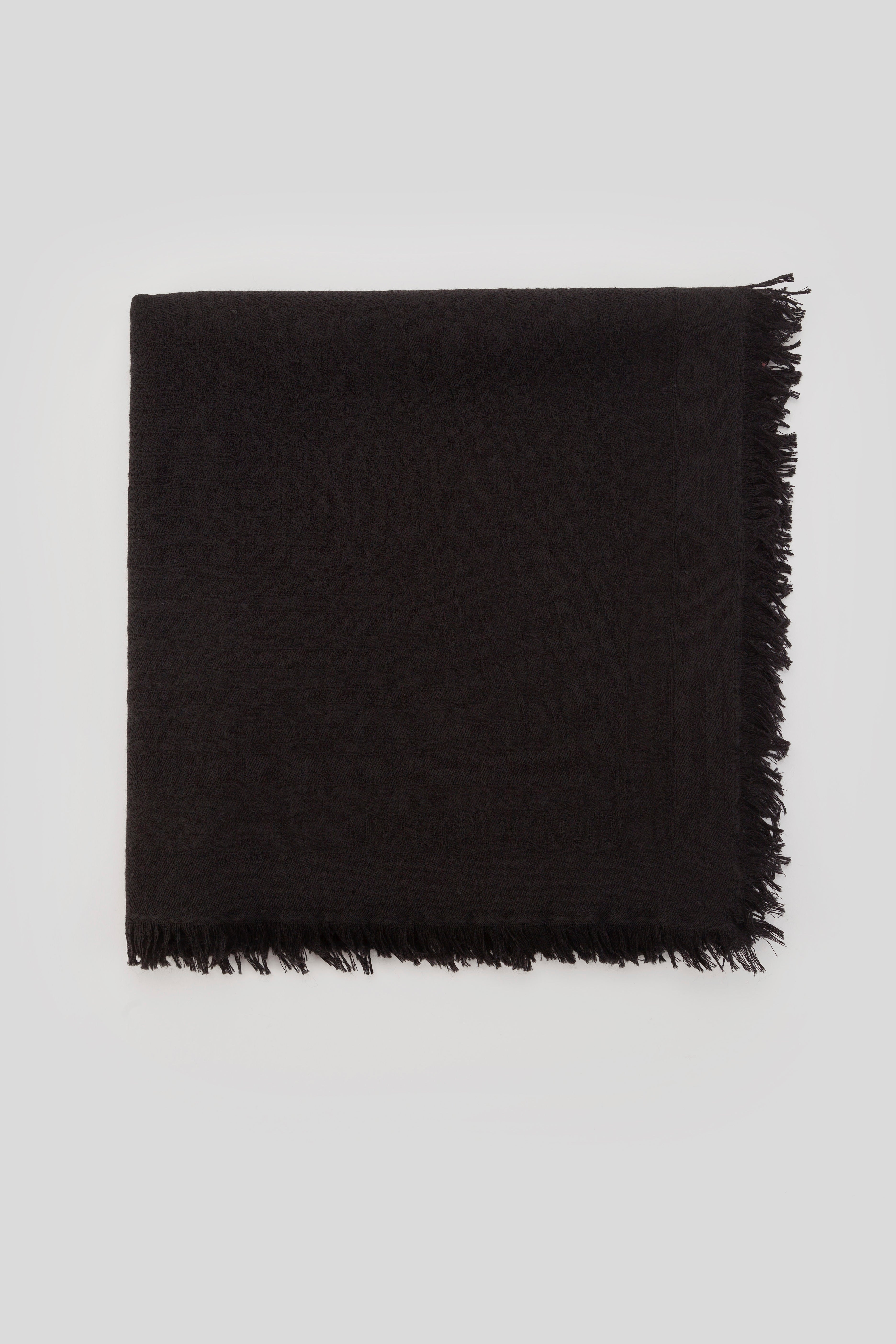 Antonio Croce's Nathalie Black Scarf with fringed edges for winter comfort, laid flat on a light gray background.