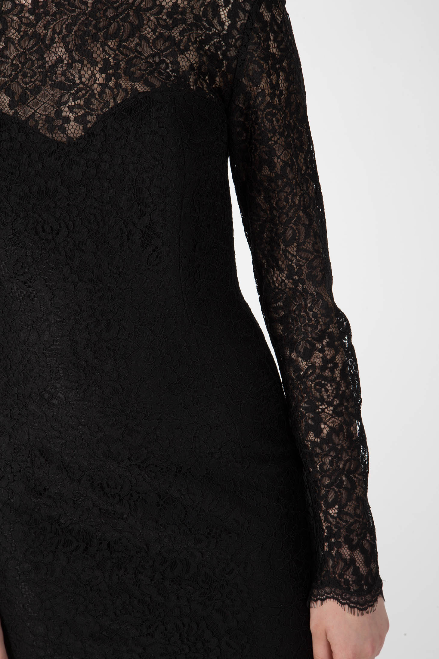 Close-up of an individual wearing the Antonio Croce Ambeta Long-Sleeve Lace Dress. The detailed pattern envelops the entire garment, offering an elegant and refined appearance. Only the upper torso and one arm are shown against a plain background.