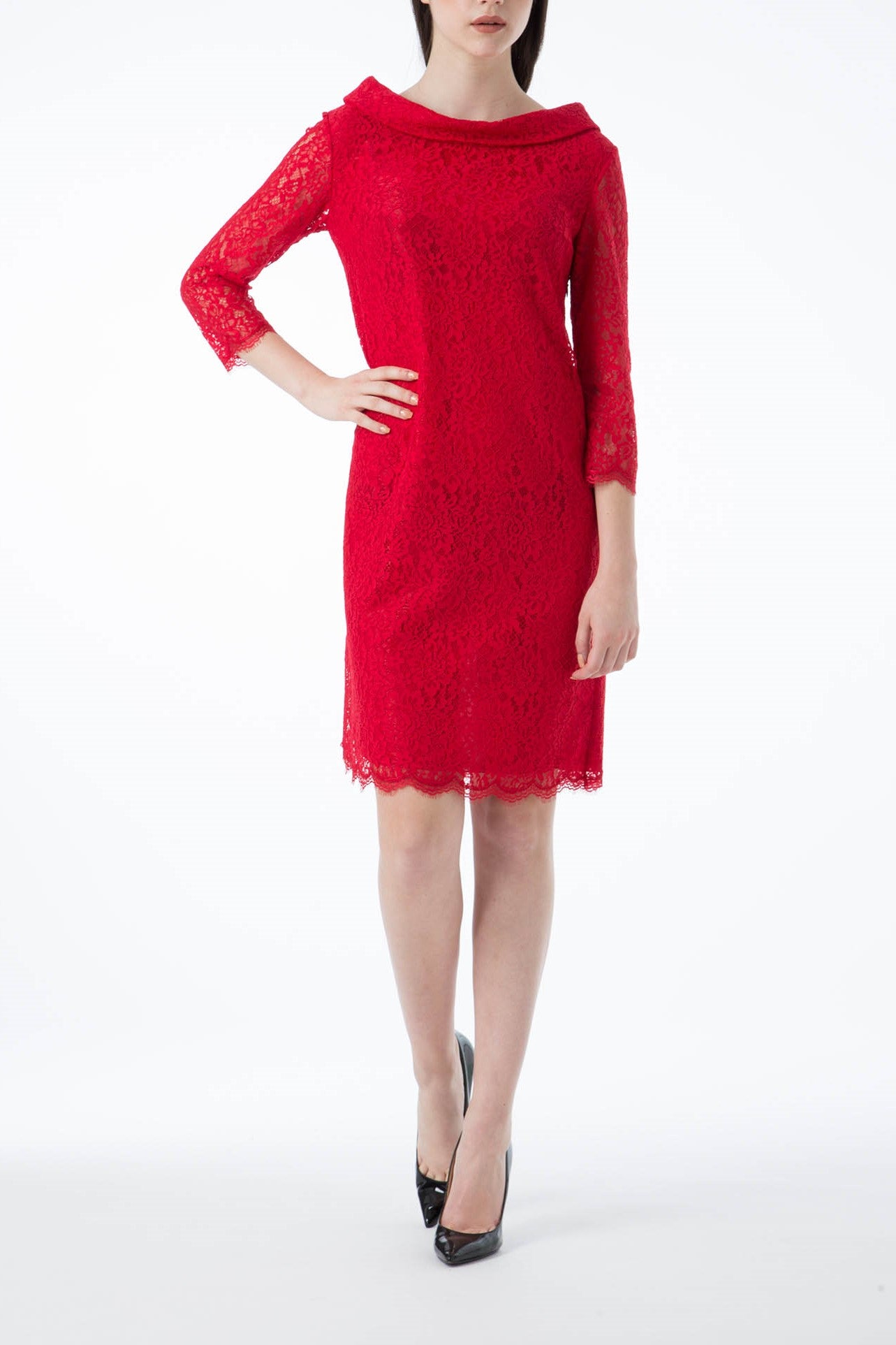 A person wearing the Antonio Croce Ana Romantic Lace Dress, featuring vintage lace in red and three-quarter sleeves, stands against a plain background. The dress boasts a scalloped hem and is paired with black high-heeled shoes. The person's hand rests on their hip, exuding timeless elegance.