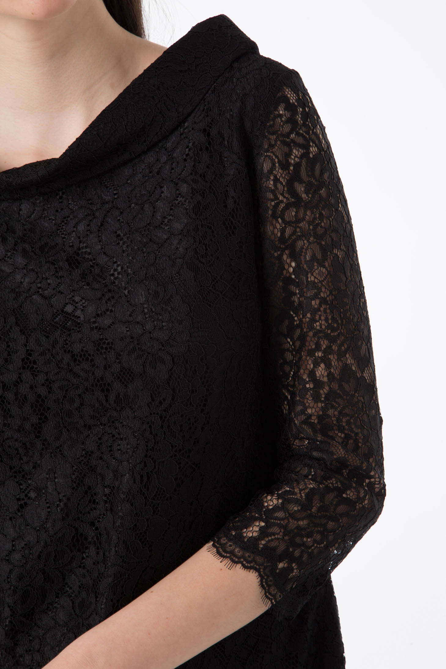 Close-up of a person wearing the Antonio Croce Ana Romantic Lace Dress, featuring vintage-style black lace with three-quarter sleeves. The delicate lace pattern is highlighted, and the person is partially visible from shoulder to waist against a plain white background.