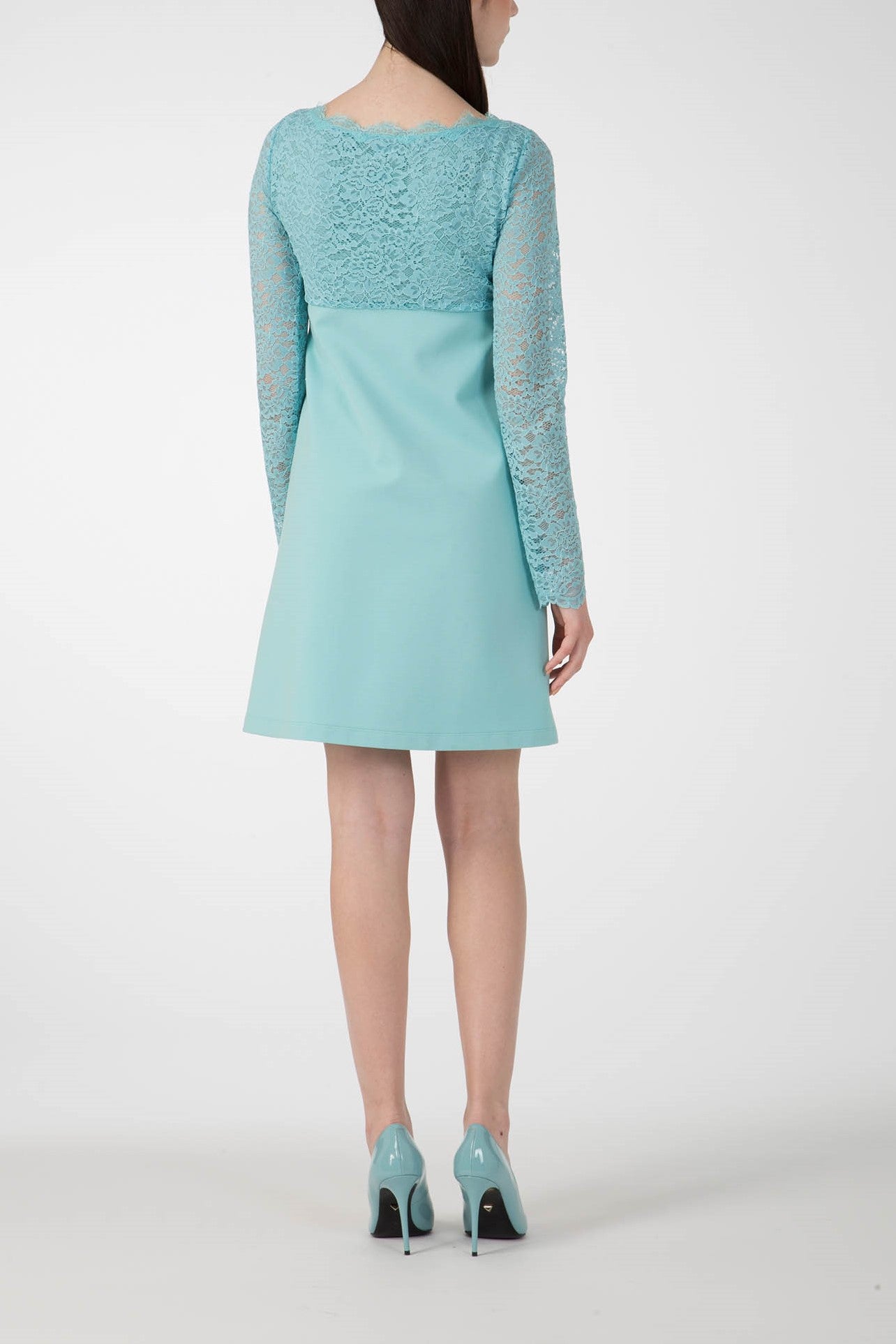 An individual is wearing the elegant Antonio Croce Ardine Two-Tone Lace Dress and standing with their back to the camera. The light blue ensemble is beautifully complemented by matching high-heeled shoes, set against a plain white background that highlights the sophisticated outfit from Antonio Croce.