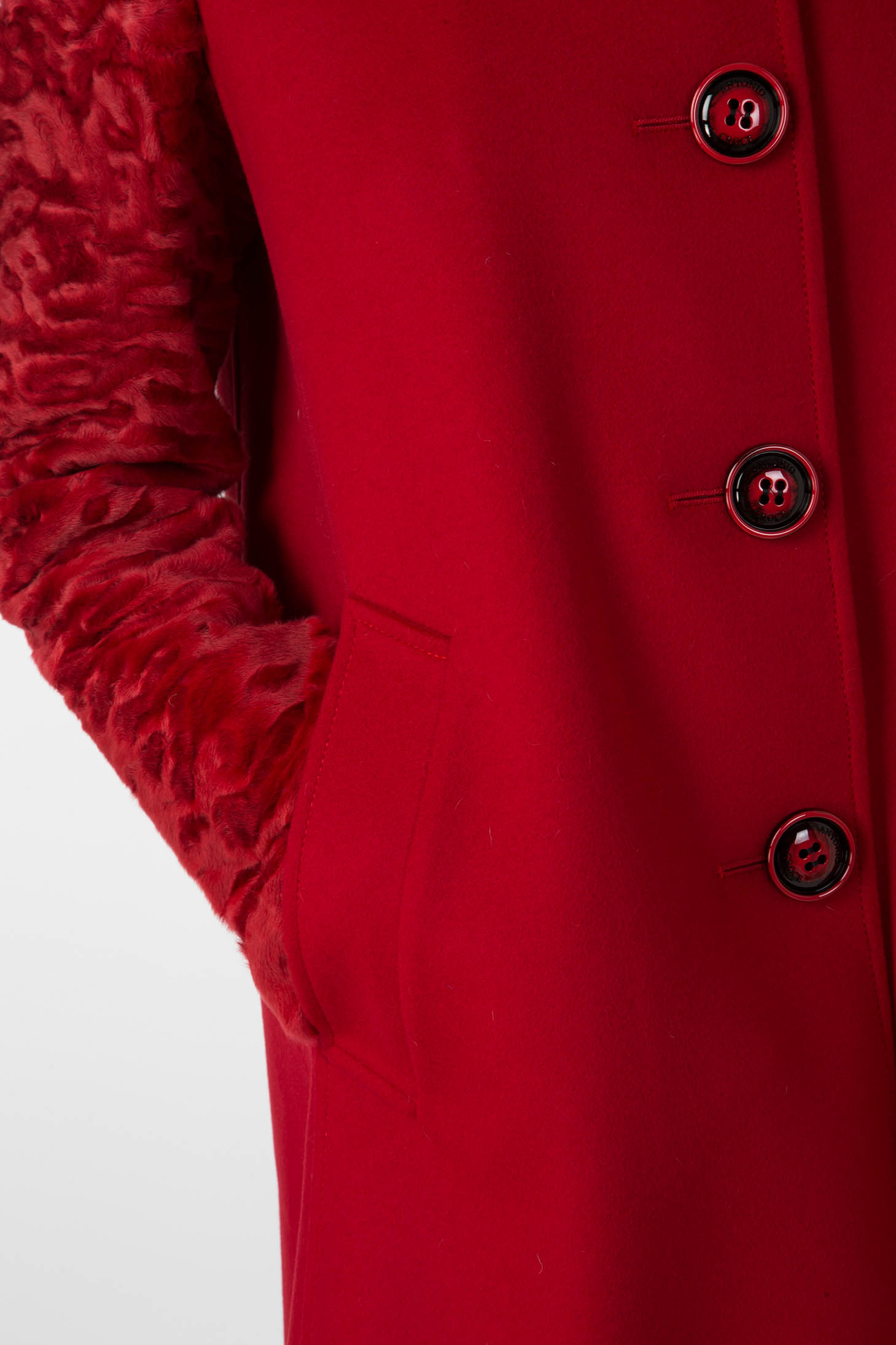 Close-up of the Antonio Croce Callie Textured Coat, featuring striking contrast sleeves and five black buttons. A hand rests nonchalantly in one of the coat's pockets against a plain background, emphasizing its vintage appeal.