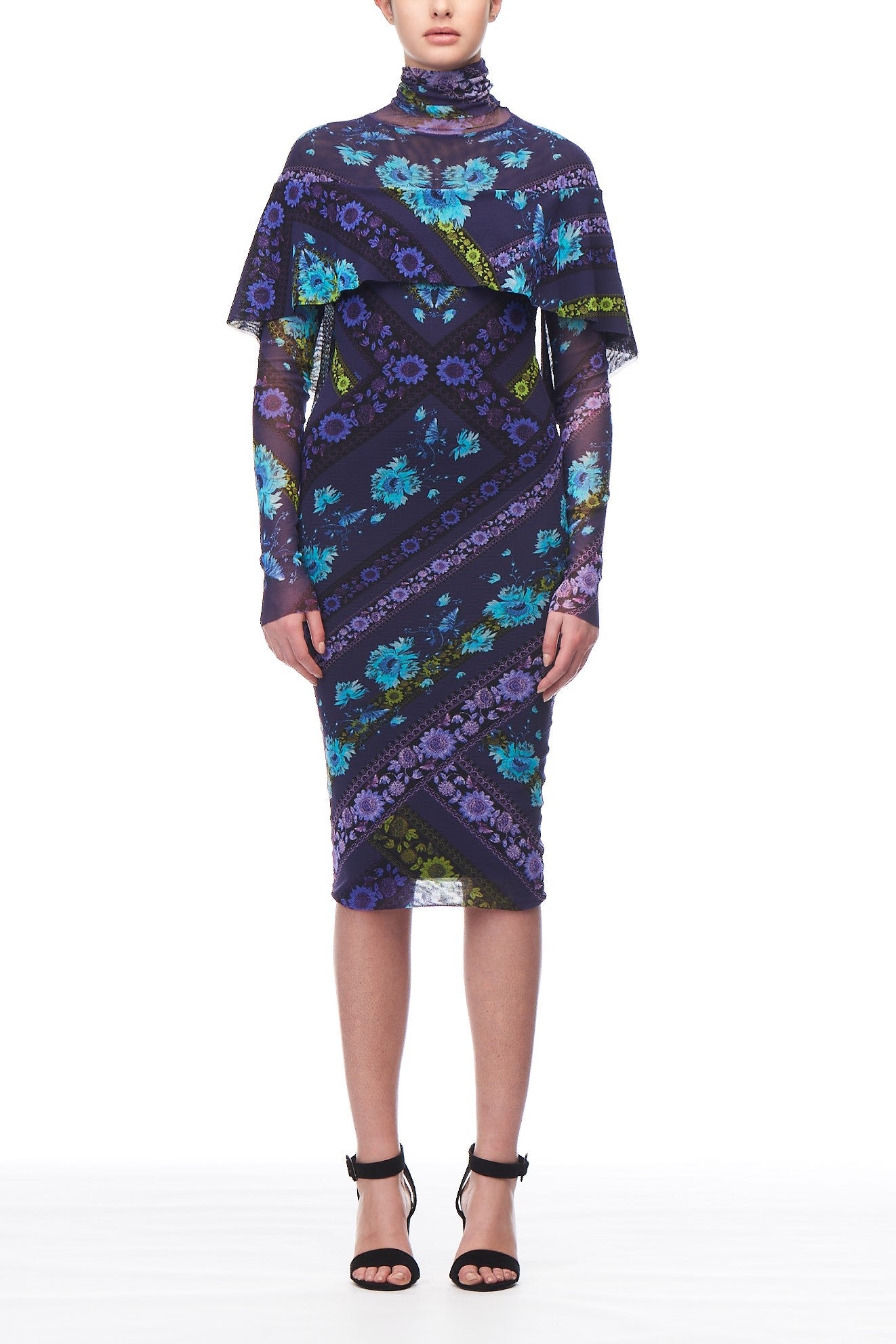 A person wearing the Fuzzi Woman Floral Short Mesh Dress in an ethereal purple floral pattern stands elegantly. Featuring Fuzzi's signature asymmetrical design with layered fabric, this vintage-inspired piece is paired perfectly with black high-heeled sandals against a plain white backdrop.