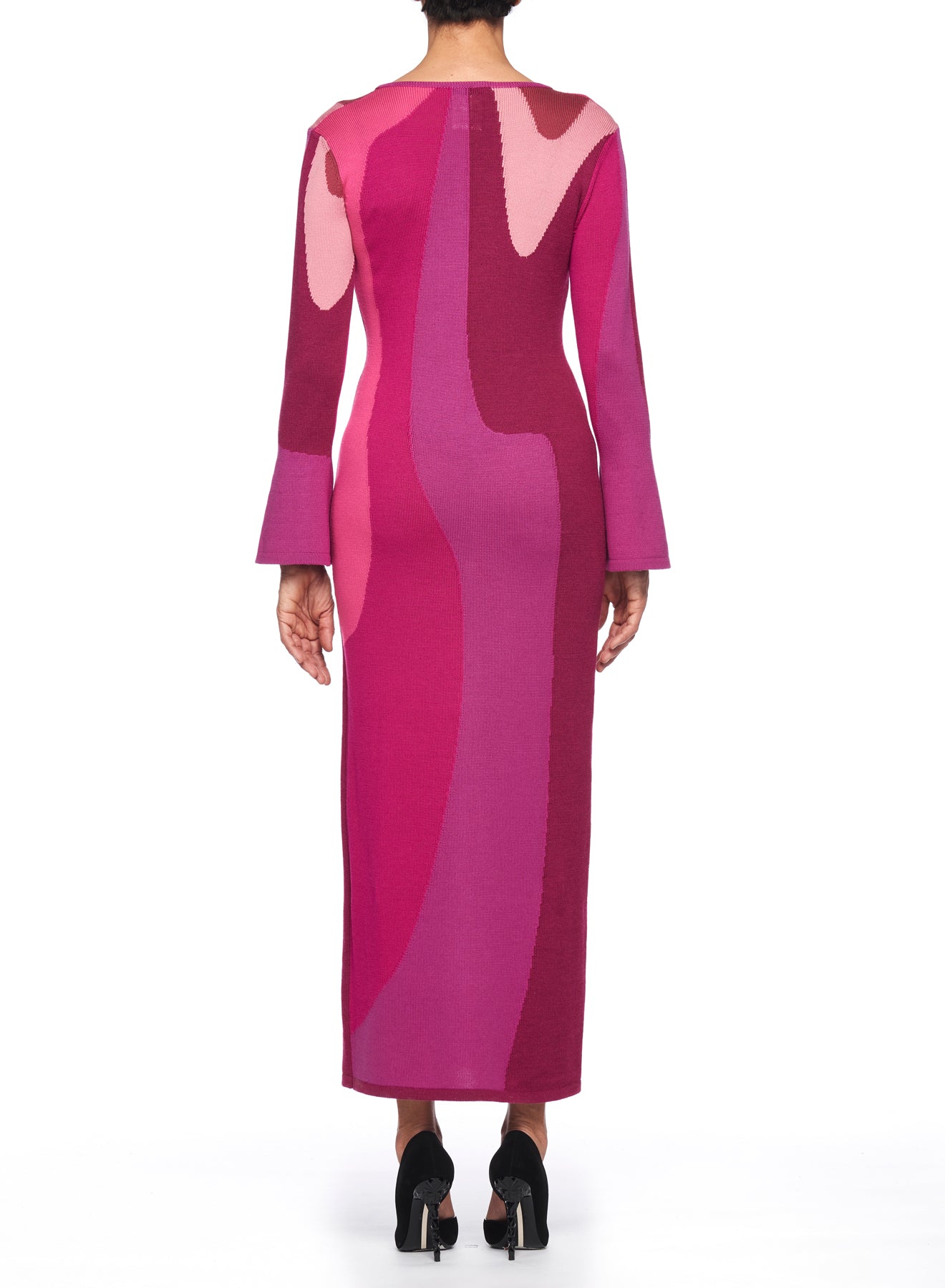 In the photo, a person in high heels is wearing the Fuzzi Woman Modern Art Midi Dress, a vintage-style piece with long sleeves and abstract pink and maroon patterns. They are captured from behind against a plain white background.