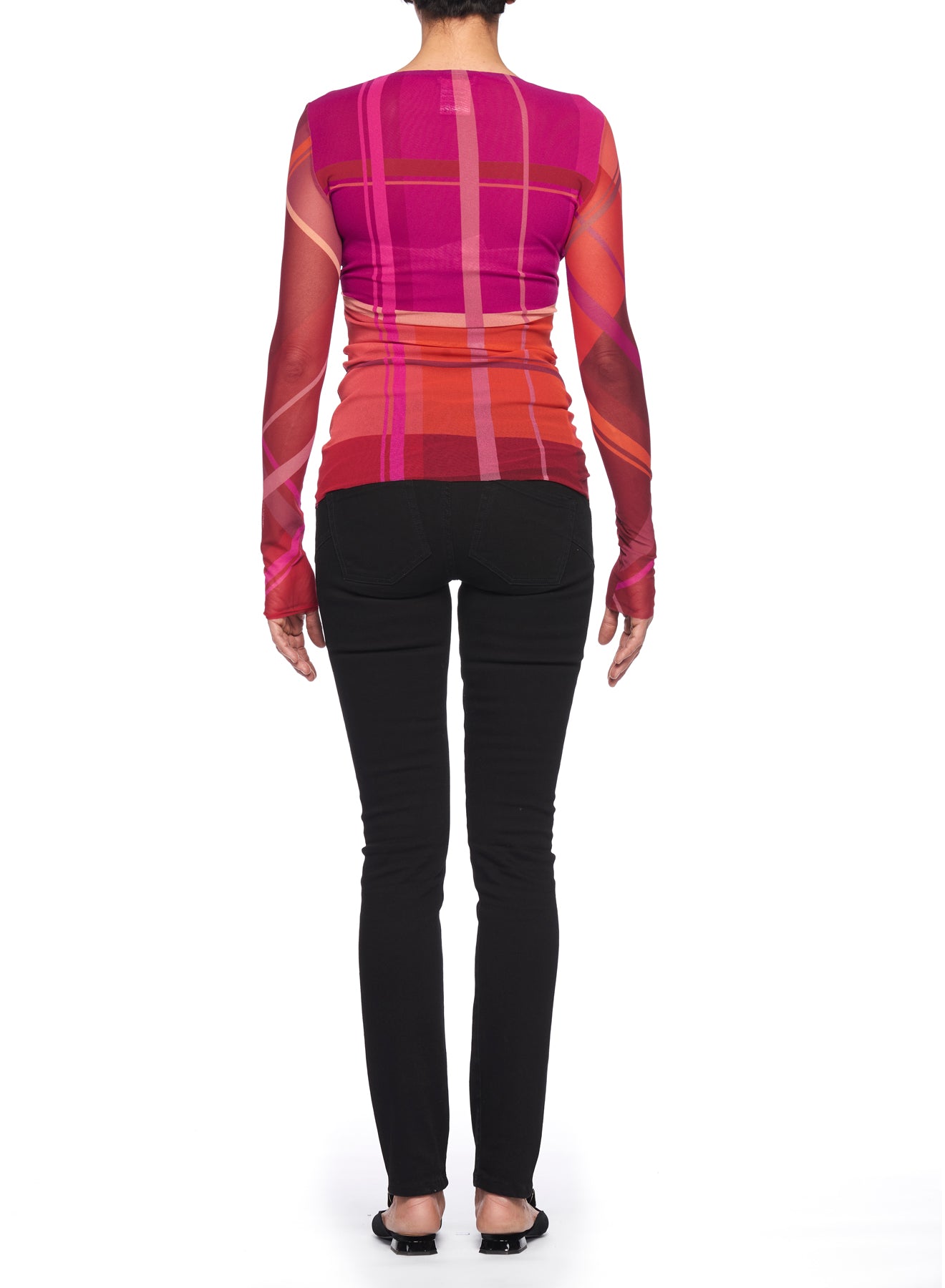 A person facing away, wearing the Fuzzi Woman Mesh Top with V-Neck, a long-sleeved, translucent, red and pink checkered piece paired with black pants. This vintage item stands out against the white background.