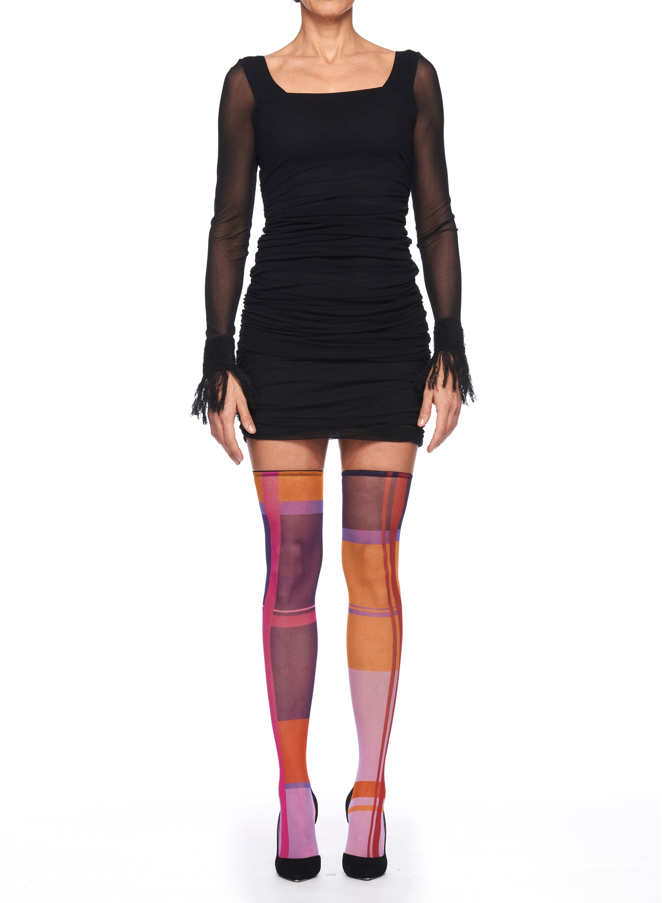 A person dressed in a black, long-sleeve dress with ruched detailing is wearing Fuzzi Woman Colorful Tights by Fuzzi and black shoes. The background is white, and the image highlights the statement piece outfit.