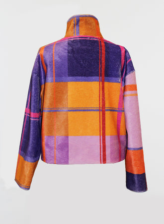 The Fuzzi Woman Colorful Turtleneck Sweater is a vibrant garment featuring a lively plaid pattern in shades of orange, purple, pink, and blue. This cozy design includes a high collar and long sleeves, set against a plain background.