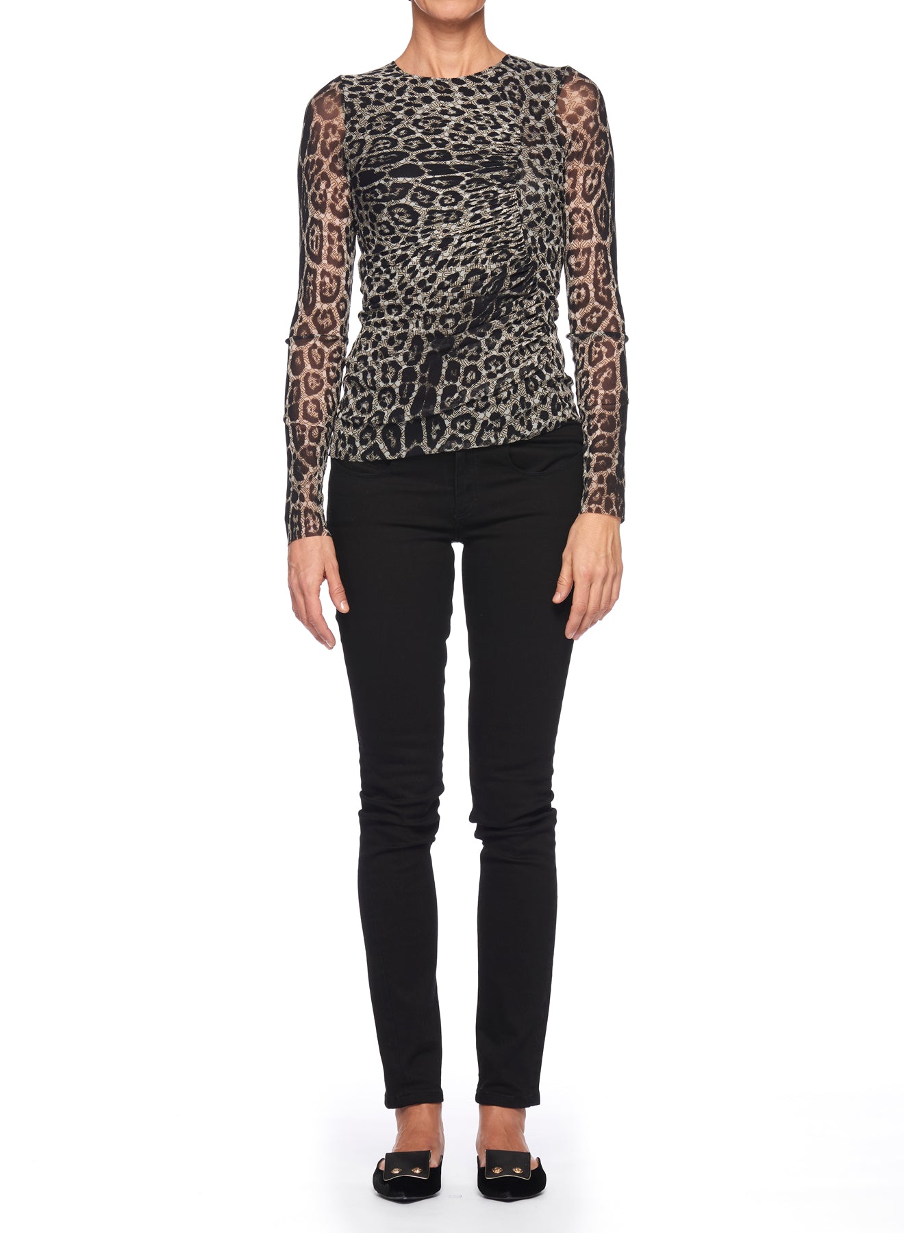 A person standing against a white background is wearing the Fuzzi Woman Leopard Print Top with Long Sleeves, crafted from sheer fabric, paired with black pants. They have black shoes, and their hands are relaxed by their sides. The head is not visible in the image.