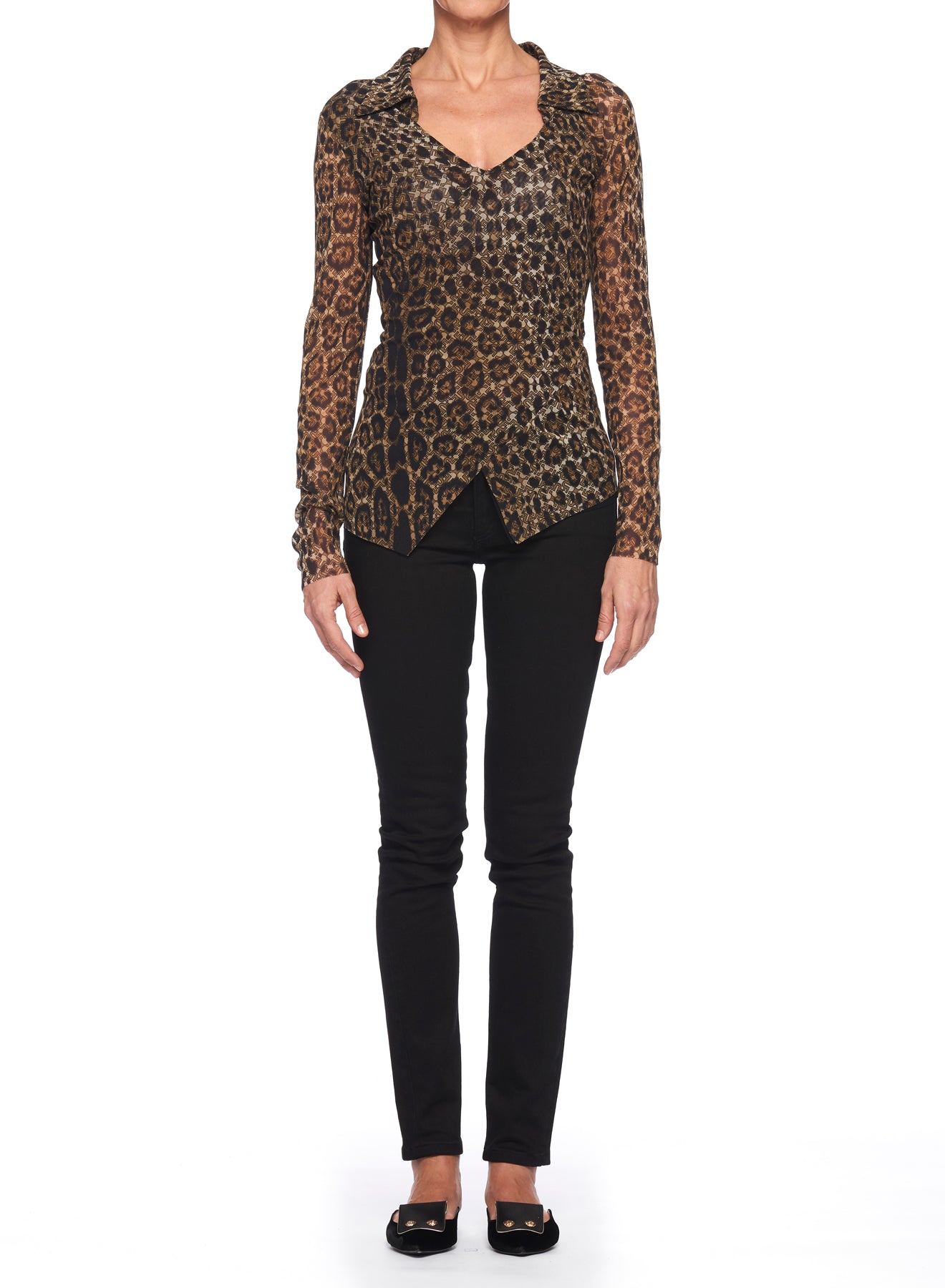 Against a white backdrop, an individual wears the Fuzzi Woman Edgy Leopard Print Mesh Top from Fuzzi, featuring a fitted design and V-neckline. They pair it with black pants and black flats, which complete the look, while the sheer fabric of the top adds an edgy flair. Their hands rest relaxed by their sides.