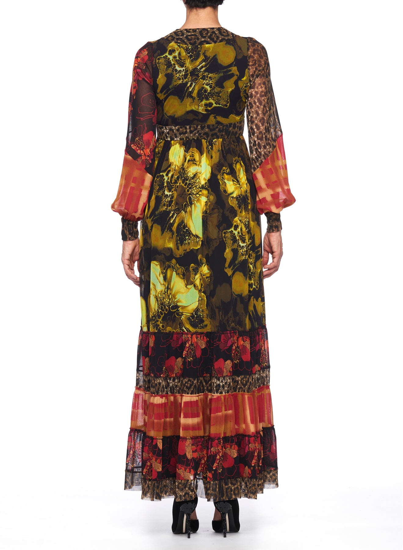 A person is seen from behind against a white background, wearing the Fuzzi Woman Boho-Chic Mixed-Print Maxi Dress. This long dress by Fuzzi showcases sheer mesh sleeves, a tiered skirt, and vibrant floral and animal prints in red, yellow, and black.