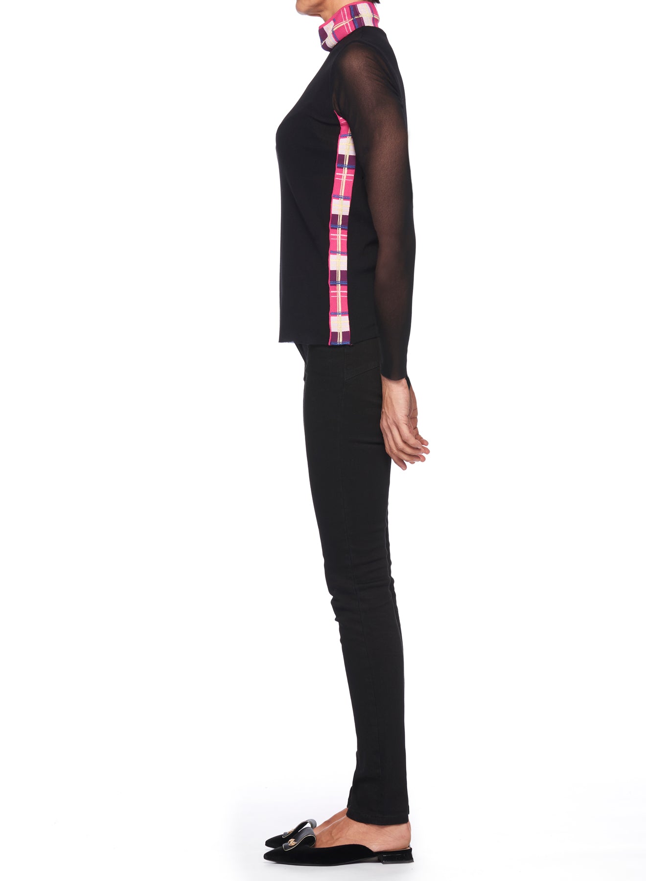 A person standing in profile against a white background is wearing black pants and the Fuzzi Woman Mesh-Sleeved Top by Fuzzi, featuring pink plaid accents. They have on black loafers embellished with gold, and their hair is tied back.